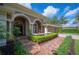 Charming exterior view with manicured landscaping, brick pathway, side-entry garage and attractive architectural details at 511 Duque Rd, Lutz, FL 33549
