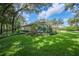 Beautiful home exterior showcasing lush lawn, mature trees, colorful landscaping, and architectural details at 511 Duque Rd, Lutz, FL 33549