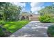 Well-maintained home with a manicured lawn, mature trees, and an inviting driveway leading to the attached garage at 511 Duque Rd, Lutz, FL 33549