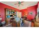 Spacious home office features red walls, hardwood floors and custom built-in shelving at 511 Duque Rd, Lutz, FL 33549