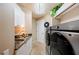 Convenient laundry room with granite countertops, built in cabinets and stainless-steel washer and dryer at 511 Duque Rd, Lutz, FL 33549