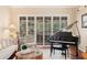 Comfortable living room with hardwood floors, plantation shutters, and a piano, creating an inviting atmosphere at 511 Duque Rd, Lutz, FL 33549