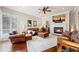 Inviting living room with a cozy fireplace, wood floors, ceiling fan, and a beautiful view at 511 Duque Rd, Lutz, FL 33549