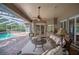 Inviting covered patio features a ceiling fan and comfortable seating for outdoor living and entertaining at 511 Duque Rd, Lutz, FL 33549