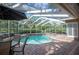 Inviting poolside view with an umbrella table and lush landscaping offers a relaxing outdoor experience at 511 Duque Rd, Lutz, FL 33549