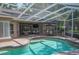 Stunning outdoor area features a sparkling pool with lush landscaping, covered patio and seating at 511 Duque Rd, Lutz, FL 33549