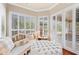 Bright sitting area with white wood shutters, daybed and ottoman near the pool at 511 Duque Rd, Lutz, FL 33549