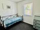 Modest bedroom with natural light, neutral walls and black metal frame bed at 5130 Pine Grove S Ter, Gulfport, FL 33707