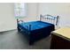 Cozy bedroom featuring a black metal frame bed with a blue blanket and natural light at 5130 Pine Grove S Ter, Gulfport, FL 33707