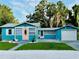 Charming blue home with a pink front door, well-manicured lawn, and a detached garage at 5130 Pine Grove S Ter, Gulfport, FL 33707