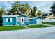 Charming home with a blue exterior, pink door, and well-manicured lawn at 5130 Pine Grove S Ter, Gulfport, FL 33707