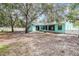 Expansive backyard featuring mature trees, a screened-in patio, and a privacy fence at 5283 Bevens Ave, Spring Hill, FL 34608