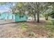 Turquoise home featuring a spacious backyard with trees and a white fence for added privacy at 5283 Bevens Ave, Spring Hill, FL 34608