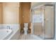 Bright bathroom with soaking tub, separate glass shower, and toilet, all tiled for easy maintenance at 5283 Bevens Ave, Spring Hill, FL 34608