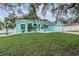 Beautifully painted turquoise home featuring a well-maintained lawn and white rock landscaping at 5283 Bevens Ave, Spring Hill, FL 34608
