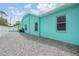 Turquoise home exterior with a rock garden and a white privacy fence at 5283 Bevens Ave, Spring Hill, FL 34608
