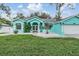 Charming turquoise home featuring decorative rock landscaping and a freshly manicured lawn at 5283 Bevens Ave, Spring Hill, FL 34608