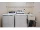 Well-equipped laundry area with a washer, dryer, shelving, and utility sink at 5283 Bevens Ave, Spring Hill, FL 34608