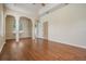 Living room featuring hardwood floors, arched doorway, large windows, and an open layout at 5283 Bevens Ave, Spring Hill, FL 34608
