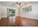 Living room featuring sliding glass doors, wood floors, and large windows for natural light at 5283 Bevens Ave, Spring Hill, FL 34608