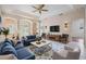 Inviting living room with blue sofas, decorative rug, ceiling fan, and view to the outdoor patio at 5283 Bevens Ave, Spring Hill, FL 34608