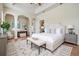 Main bedroom featuring tray ceiling, wood floors, bench, and adjacent sitting area at 5283 Bevens Ave, Spring Hill, FL 34608