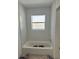 Bright bathroom featuring new white tile, bathtub, and window at 538 Crystal Dr, Madeira Beach, FL 33708