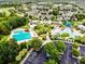 Beautiful aerial view of community pools, parking, and houses surrounded by mature trees and landscaping at 5717 Fishhawk Ridge Dr, Lithia, FL 33547