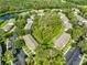 Aerial view of multi-Gathering complex near pond, featuring green spaces, parking, and tree-lined streets at 5717 Fishhawk Ridge Dr, Lithia, FL 33547