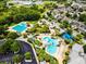 Expansive aerial view showcasing community pools, playgrounds, and ample green space surrounded by lush trees at 5717 Fishhawk Ridge Dr, Lithia, FL 33547