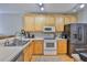Well-lit kitchen with white countertops, stainless steel appliances, and light wood cabinetry at 5717 Fishhawk Ridge Dr, Lithia, FL 33547
