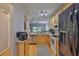 Functional kitchen featuring stainless steel appliances, light wood cabinets, and a view into the living area at 5717 Fishhawk Ridge Dr, Lithia, FL 33547