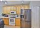 Kitchen showcases wood cabinets, stainless steel refrigerator and modern appliances at 5717 Fishhawk Ridge Dr, Lithia, FL 33547