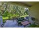 Covered outdoor patio with seating area surrounded by lush greenery and mature trees at 5717 Fishhawk Ridge Dr, Lithia, FL 33547