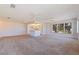 Open-concept living room featuring large windows, ceiling fans, and a pass-through to the well-lit kitchen at 5725 80Th N St # 301, St Petersburg, FL 33709