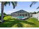This spacious backyard features a screened-in pool, lush lawn, and is surrounded by mature trees and well-maintained landscaping at 5884 51St S St, St Petersburg, FL 33715