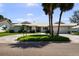 Beautiful exterior view of a well-maintained one-story home, enhanced by palm trees and a circular driveway at 5884 51St S St, St Petersburg, FL 33715