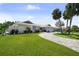 Charming single-story home with lush landscaping, mature palm trees, and a curved paver driveway at 5884 51St S St, St Petersburg, FL 33715