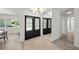 Hallway with coat closet, light wood floors, with a modern light fixture and view of the outside at 5884 51St S St, St Petersburg, FL 33715