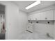 Well-lit laundry room with ample cabinetry, a utility sink, and sleek flooring at 5884 51St S St, St Petersburg, FL 33715