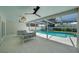 Covered outdoor living space overlooking pool, with travertine tile floors and modern furniture at 5884 51St S St, St Petersburg, FL 33715