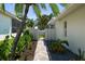 Enchanting walkway with lush greenery leads to a private entrance and complements the home's pristine exterior at 5884 51St S St, St Petersburg, FL 33715