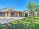 Spacious backyard featuring a patio area, well-manicured lawn, and privacy landscaping at 6001 Lemon Tree Ct, Tampa, FL 33625
