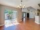 Charming dining area with wood-look tile flooring, a chandelier, and sliding door access to the outdoor patio at 6001 Lemon Tree Ct, Tampa, FL 33625