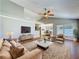 Bright living room with wood floors, a ceiling fan, and comfortable seating with a view of the dining area at 6001 Lemon Tree Ct, Tampa, FL 33625
