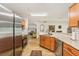Open kitchen with stainless appliances, wood cabinets, granite counters with a view into the living spaces at 636 Chatham Walk Dr, Ruskin, FL 33570