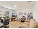Living room features wood-look flooring, a skylight, a large flat screen TV, and window with natural light at 636 Chatham Walk Dr, Ruskin, FL 33570