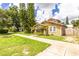 Charming yellow two-story home featuring a well-maintained lawn and mature trees at 6408 N Central Ave, Tampa, FL 33604