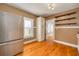 Bright kitchen with stainless steel refrigerator, wooden shelves, and hardwood floors, creating a functional space at 6408 N Central Ave, Tampa, FL 33604