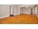 Open living area with hardwood floors and neutral wall colors, and an entry with a storm door at 6408 N Central Ave, Tampa, FL 33604